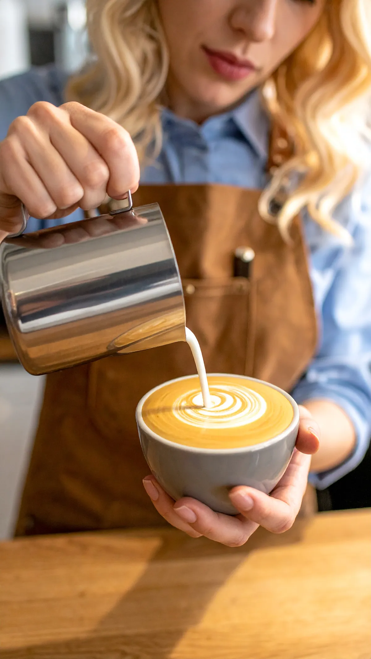 Dame heller melk i kaffekopp